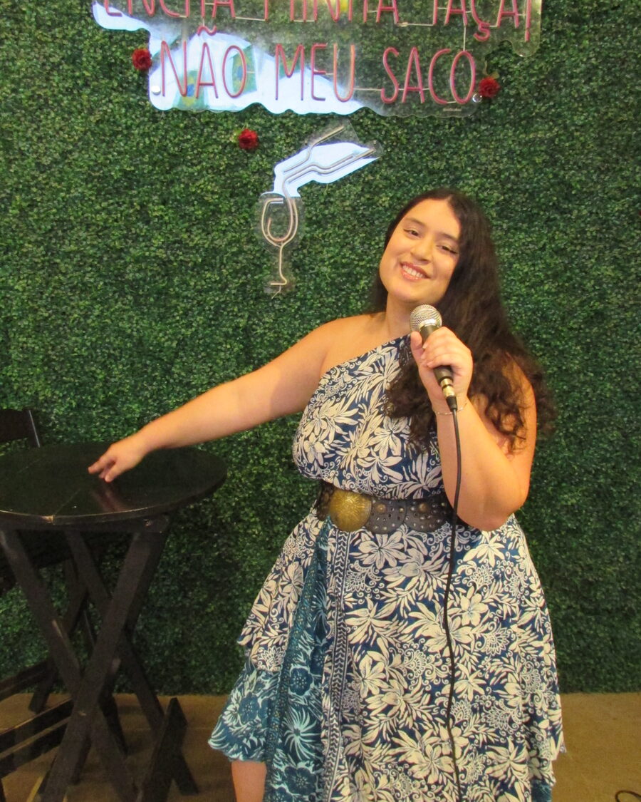 Diana Blum no palco, sorrindo para o público